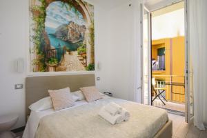 a bedroom with a bed with a painting on the wall at SpeziAMo Rooms in La Spezia +20 photos