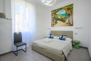 a bedroom with a bed and a painting on the wall at SpeziAMo Rooms in La Spezia