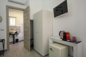 a bathroom with a toilet and a tv on a wall at SpeziAMo Rooms in La Spezia