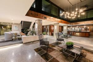 a lobby of a building with tables and chairs at Slaviero Hotel Curitiba Centro in Curitiba