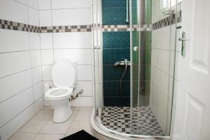 a bathroom with a toilet and a glass shower at The Cottage in Lilongwe +15 photos