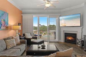 a living room with a couch and a fireplace at Sanctuary at Redfish 2115 by Newman-Dailey in Santa Rosa Beach