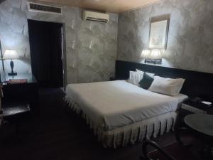 a bedroom with a bed and a table and two lamps at Alsafina hotel in Lahore +18 photos