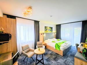 a hotel room with a bed and a table and chairs at Wellness Hotel Garni Krone in Baiersbronn +99 photos