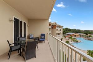 a balcony with a table and chairs and a pool at Sanctuary at Redfish 2115 by Newman-Dailey in Santa Rosa Beach