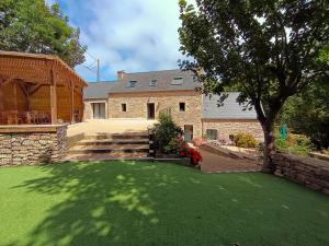 a house with a yard of green grass at Le moulin de Kerloroc in Ploudalmézeau