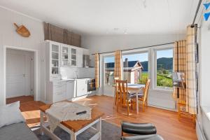 a kitchen and dining room with a table and chairs at Roksoy for rent in Sortland