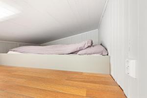 a bed in a small room with a wooden floor at Roksoy for rent in Sortland