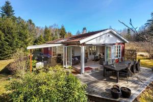 a small house with a deck with a table at 84300-Ebeltoft-Bogfinkevej-17 in Fuglslev