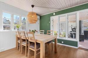 a dining room with a wooden table and chairs at 84300-Ebeltoft-Bogfinkevej-17 in Fuglslev