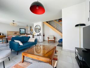 a living room with a blue couch and a table at Casa Avrillé in Avrillé