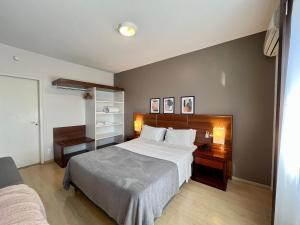 a bedroom with a large bed and a desk at Studio apartment in downtown Joinville, SC in Joinville