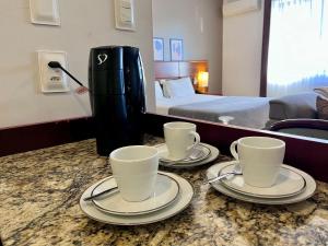 two cups and saucers on a counter in a hotel room at Studio apartment in downtown Joinville, SC in Joinville +20 photos