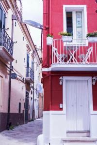 a red building with a balcony on a street at Dimora Via Roma in San Severo