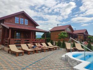 a man laying on lounge chairs next to a house at Kuća Pored Sunca in Kruševac