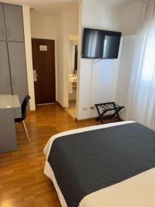 a bedroom with a bed with a television on the wall at Hotel República in Villa María