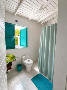 a bathroom with a toilet and a green shower curtain at Siloe Cove Hospedaje Campestre in San Andrés +78 photos