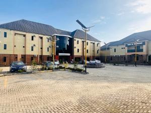 a parking lot in front of a building with a windmill at Goldstep hotel Okpaka in Warri