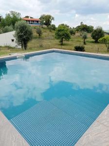 a large swimming pool with blue water at Typical Alentejo House in Mora +6 photos