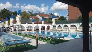a swimming pool with blue and white umbrellas and chairs at Hotel Elite in Turin
