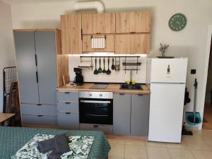 a kitchen with a white refrigerator and a stove at Студио Forest, к-с Нестинарка in Tsarevo +16 photos