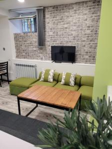 a living room with a green couch and a tv at Дом 33 возле клиники Астхик in Yerevan