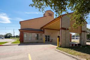 a building with a parking lot in front of it at Garland Inn & Suites near Dallas TX in Garland +14 photos