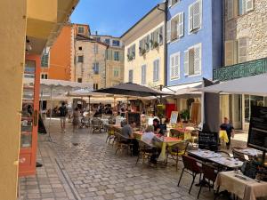 a group of people sitting at tables in a street at Luxurious Provencal cottage with private Pool, Terrace & Garden in Vence