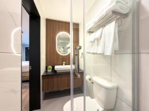 a bathroom with a toilet and a sink at Alpine Inn Abbotsford in Abbotsford +34 photos