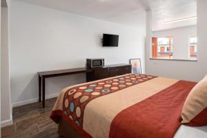 a bedroom with a bed and a desk with a microwave at Garland Inn & Suites near Dallas TX in Garland