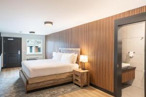 a bedroom with a bed with a wooden wall at Alpine Inn Abbotsford in Abbotsford