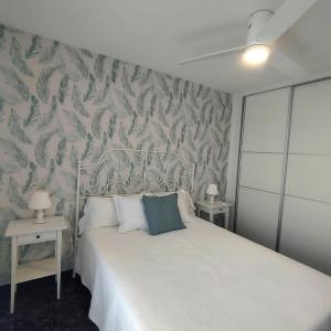 a bedroom with a white bed and a wallpaper at Apartamento Ferrara in Torrox Costa +17 photos