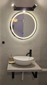 a bathroom with a large white sink and a mirror at Teos Sunset View Apartment in Batsi +12 photos