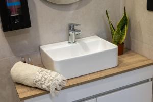a white sink on a wooden counter in a bathroom at Latitude Guest House in Cantanhede