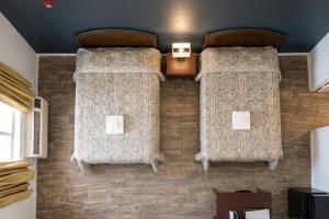 two beds on the wall of a room at Garland Inn & Suites near Dallas TX in Garland