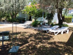 a swing set in a park with trees and benches at Our Summer Nest in Panormos Skopelos