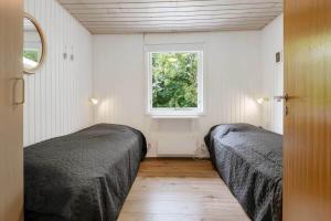 a bedroom with two beds and a window at C11252-hemmet-Anevej-7 in Hemmet