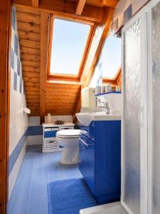 a bathroom with a toilet and a sink and a window at Appartamento Belvedere in Asiago +15 photos