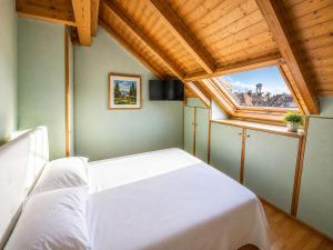 a bedroom with a white bed and a window at Appartamento Belvedere in Asiago