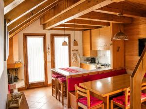 a kitchen with a wooden table and chairs and a table and a counter at Appartamento Belvedere in Asiago