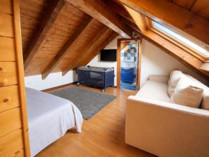 a bedroom with a bed and a couch in a attic at Appartamento Belvedere in Asiago