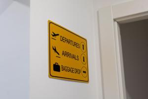 a yellow sign on a wall with arrows on it at Latitude Guest House in Cantanhede