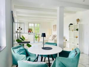 a living room with a table and blue chairs at Appartement "Hörnli Seeliebe" in Kreuzlingen