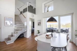 a white dining room with a white table and chairs at 1166-Ringkobing-Havstien-388 in Søndervig