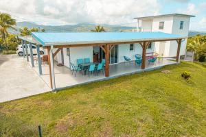 a house with a blue roof and a yard at Villa Syleone in Sainte-Marie