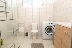 a bathroom with a toilet and a washing machine at Villa Syleone in Sainte-Marie +13 photos