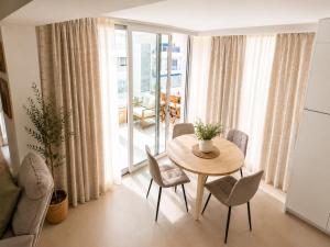 a dining room with a table and chairs and a large window at Beach Apartment in Torre del Mar in Torre del Mar