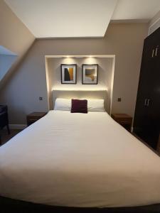 a bedroom with a large white bed with two pictures on the wall at Fenwick Street Hotel by EPIC, Central Rooms Near Waterfront & Liverpool ONE in Liverpool