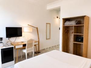 a hotel room with a desk and a bed and a bedroom at Domus Maris Relais Boutique Hotel in Sciacca