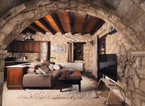 a living room with a couch in a stone wall at Kidóni Villas in Gaïtánion